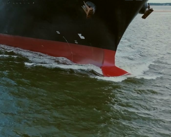 The bow of a cargo ship cutting through the sea